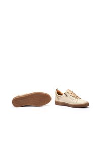 Beige sneaker met een bovenwerk van glad leer, een gestructureerde rubberen zool, ronde neus, vetersluiting aan de voorkant en een ritssluiting aan de zijkant voor gemakkelijke toegang.