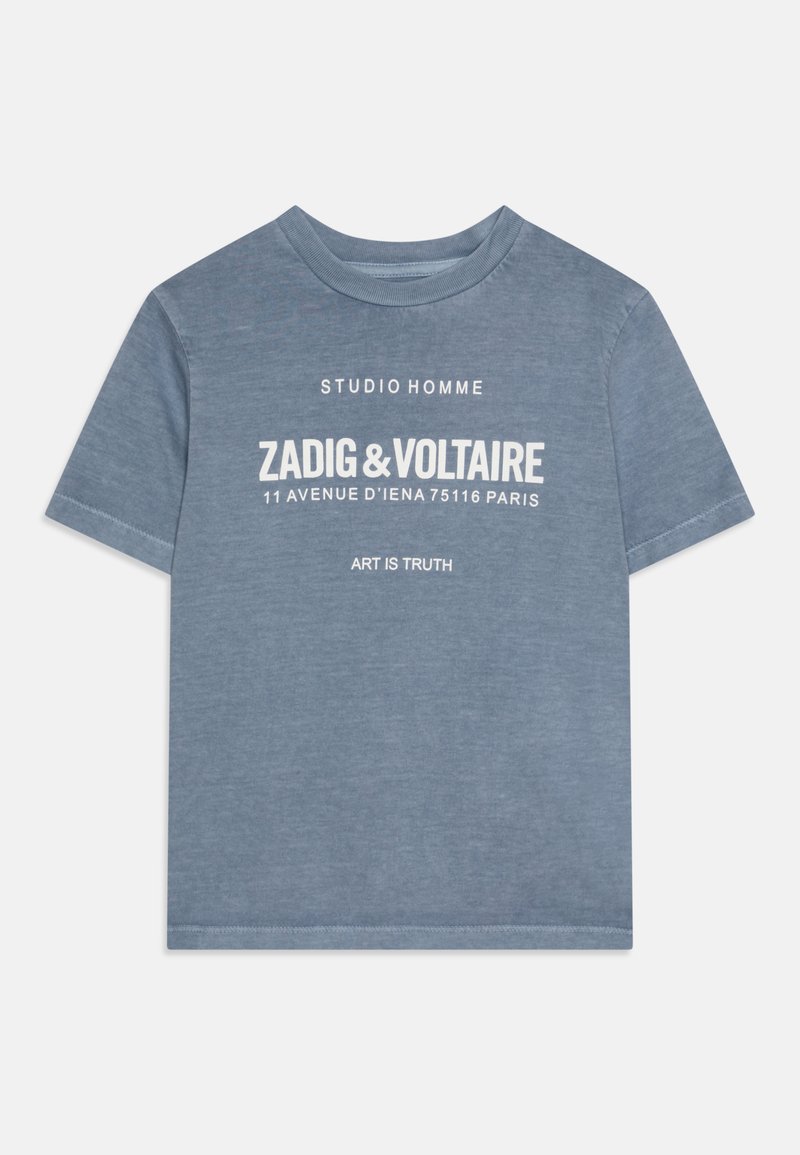 Gaiši zils īsām piedurknēm T-krekls, izgatavots no mīksta kokvilnas. Ar baltām drukātām uzrakstiem, tostarp zīmola nosaukums un atrašanās vieta, centrēti priekšā.