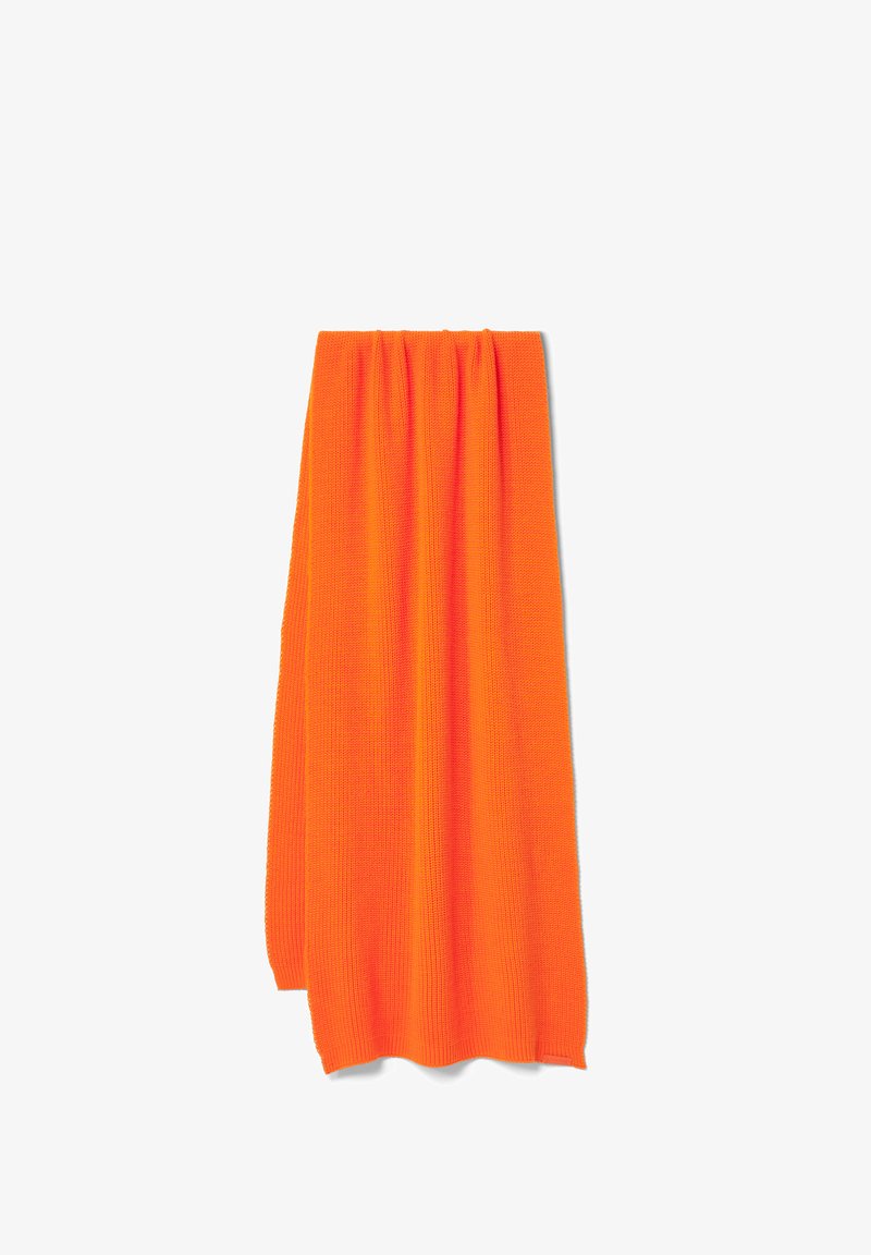 Lys orange strikket stof hænger lodret. Det har et struktureret, ribbet mønster med blødt, fleksibelt materiale. Ingen pynt eller udsmykninger er synlige.