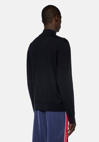 Maglione a pullover nero con orlo e polsini a coste, realizzato in un leggero tessuto a maglia, dotato di colletto classico e vestibilità rilassata.