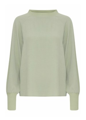 Lichtgroene lange mouwtop met een relaxte pasvorm, ronde halslijn, ribgebreide manchetten en een textuurstof. Beschikt over raglanmouwen en een minimalistisch ontwerp.