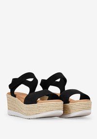 Sandalias de cuña de ante negro con dos correas anchas y puntera abierta, que presentan una entresuela de yute trenzado y una suela de goma blanca sólida.