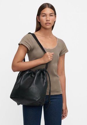 Borsa a sacco in pelle nera con una texture morbida e forma arrotondata, dotata di spalline sottili e un'apertura a coulisse per la chiusura.