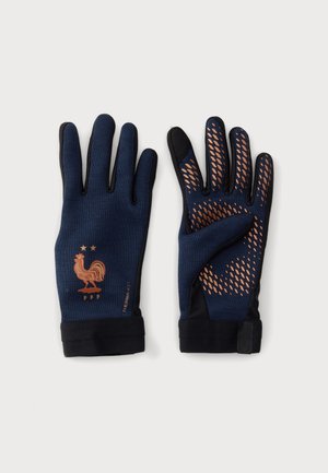 Paire de gants bleu marine avec bouts des doigts noirs, motifs de grip orange sur une paume, et logo de coq orange avec deux étoiles au dos de l’autre gant.