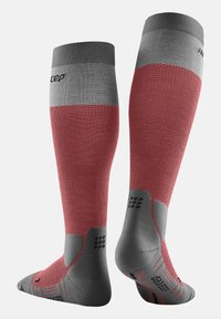 Calze a compressione lunghe fino al ginocchio in rosso e grigio, con texture a costine, design ergonomico e dettagli decorativi sulla suola.