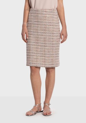 Tweedová sukňa po kolená v ružovej, krémovej a viacfarebnej kombinácii, s priamym strihom a bez viditeľných zapínaní. Spárovaná so striebornými sandálmi.