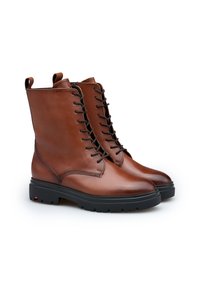 Bruine leren enkellaarzen met een gladde afwerking, veters aan de voorkant, een rubberen zool en zijgrepen voor gemakkelijk aan- en uittrekken. Gestikte details aan de zijkanten.