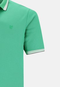Grön polo t-shirt med en texturerad tyg, som har en kontrasterande krage, broderad logotyp på bröstet och korta ärmar.