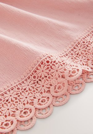 Tissu rose à surface texturée, orné d'une bordure en dentelle complexe avec des motifs circulaires le long du bord. Couleur douce et pastel.