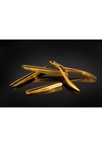 Zestaw precyzyjnych pęset i obcinaczy do paznokci ze stali nierdzewnej w kolorze złotym, ułożonych na refleksyjnej czarnej powierzchni.