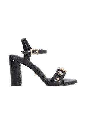 Schwarze, hochhackige Sandale mit strukturiertem Obermaterial, verziertem Riemen mit Perlen und goldener Akzentuierung sowie einem breiten Blockabsatz.