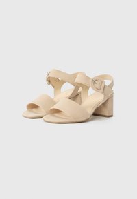 Beige nubukist kantidega sandaalid laia esistrapiga, pahkluu rihma ja pildi kinnitusega ning plokk-kandiga. Sile tekstuur ja minimalistlik disain.