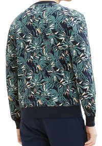 Pánská mikina s tmavě modrým pozadím a tropickým potiskem listů v tyrkysové a krémové barvě, žebrovanými manžetami a lemem a měkkou texturou látky.
