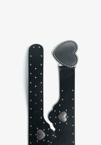 Zwarte leren riem met een hartvormige gesp, voorzien van studaccenten en uitsparingen op de band, met een gladde textuur.