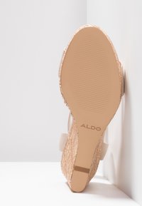 Růžové klínové sandály z jemného texturovaného materiálu, hladká podrážka a texturované dno s drážkami; logo ALDO na podrážce.