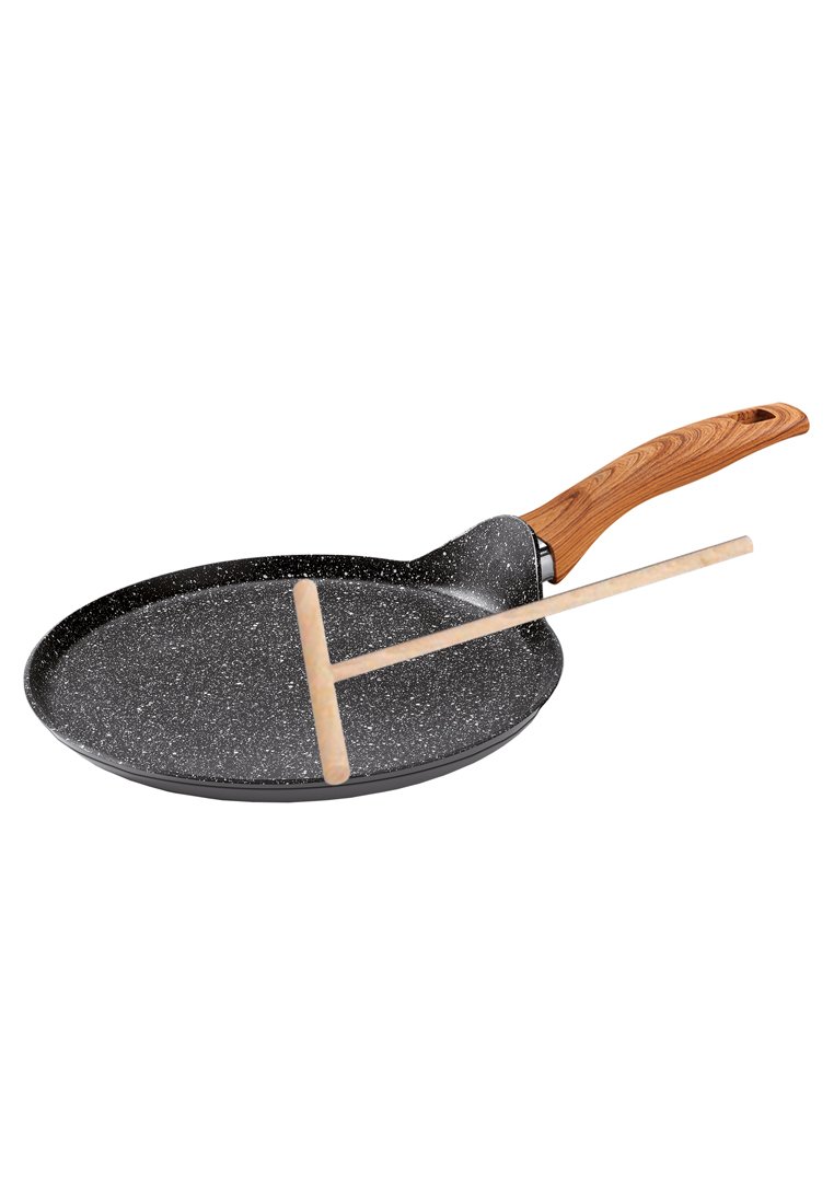 Poêle à crêpe antiadhésive avec un revêtement noir à pois, une poignée en bois et une spatule en bois reposant sur le bord. Forme circulaire et plate.