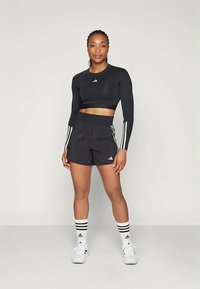 Must have Adidas logo ka mustata must sleeves top musta ja musta lühikesed püksid küljel triipudega, valged sokid ja tossud.