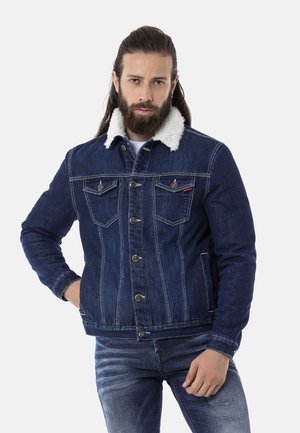Denimjacke mit dunklem Blauton, gefüttertem Kragen aus Fell, Metallknopfverschluss und zwei Brusttaschen; gerippte Bündchen und Saum.