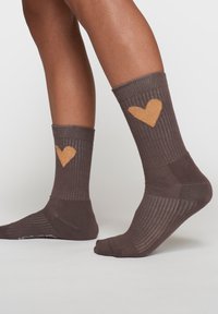Calze a coste marroni con un design a cuore dorato testurizzato sul risvolto. Presentano una punta e un tallone rinforzati per una maggiore durata.