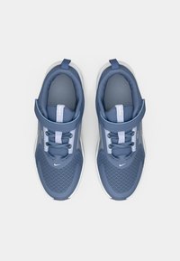 Baskets en maille bleue avec semelles blanches, dotées de lacets élastiques, d'une sangle à scratch et d'un logo discret sur la languette et le côté.