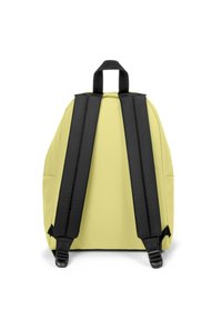 Sac à dos jaune de forme arrondie, avec des bretelles rembourrées noires et une poignée supérieure. Il présente une texture de tissu lisse et aucune poche visible.
