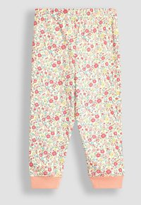 Pantalons à motif floral sur un fond clair, ornés de fleurs rouges, roses, jaunes et bleues. Tissu doux avec une finition ajustée aux chevilles en orange.