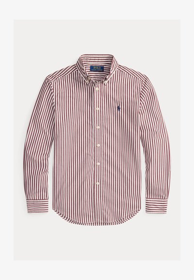 Svītrains pogām tērps sarkans un balts. Iespējas ietver klasisku apkakli, garas piedurknes un mazu izšūtu logotipu kreisajā krūtī.