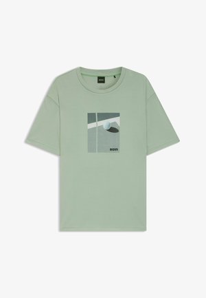 T-shirt à manches courtes vert clair avec un graphique de terrain de tennis et une balle, ainsi que le logo "BOSS" sur la poitrine.