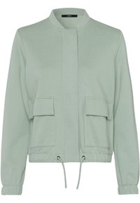 Light green long-sleeve jacket with a round collar, hidden front closure, two front flap pockets, and adjustable drawstring hem.