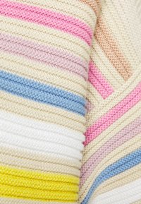 Zbliżenie na miękką, dzianą tkaninę z poziomymi paskami w kolorach żółtym, białym, niebieskim, różowym, beżowym i jasnofioletowym.