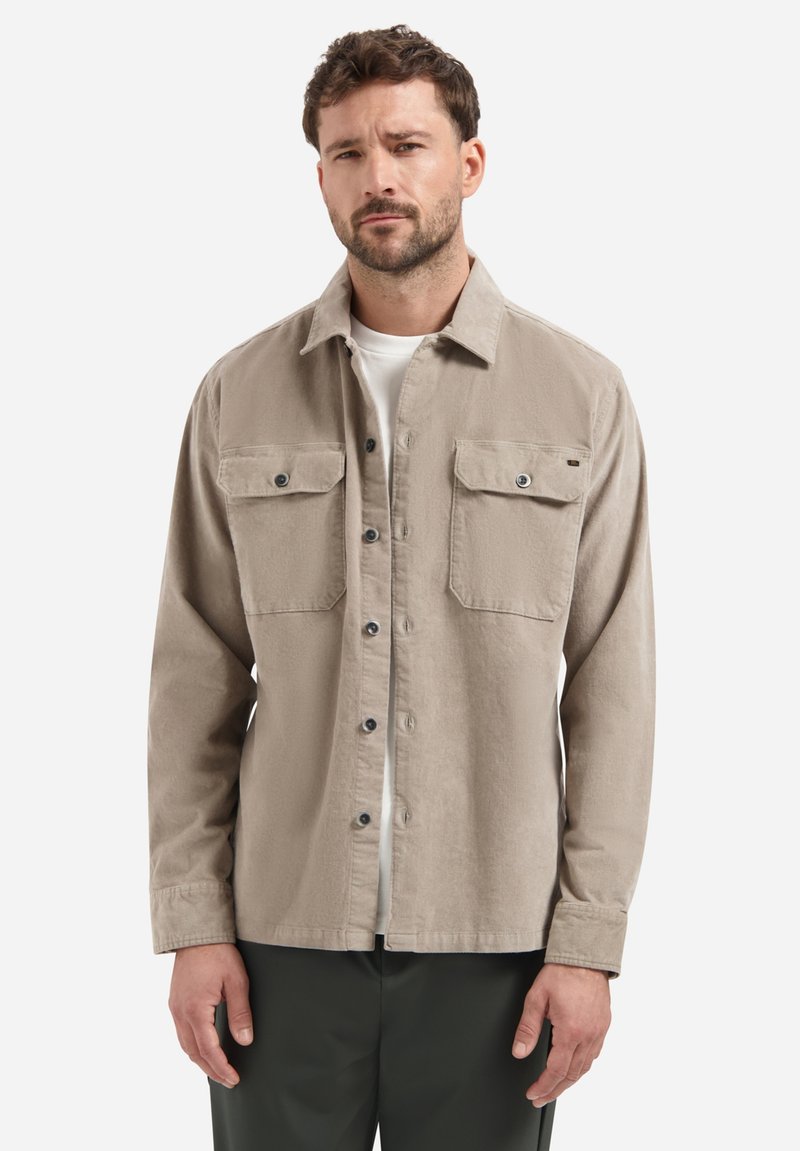 Light taupe button-up shirt made of textured fabric with two chest pockets and a collared neckline, paired with a white undershirt.
