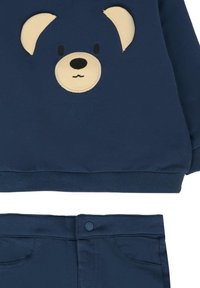 Marineblauwe sweatshirt met een berengezicht appliqué, met beige oren en details. Gecombineerd met bijpassende marineblauwe broek met voorzakken.