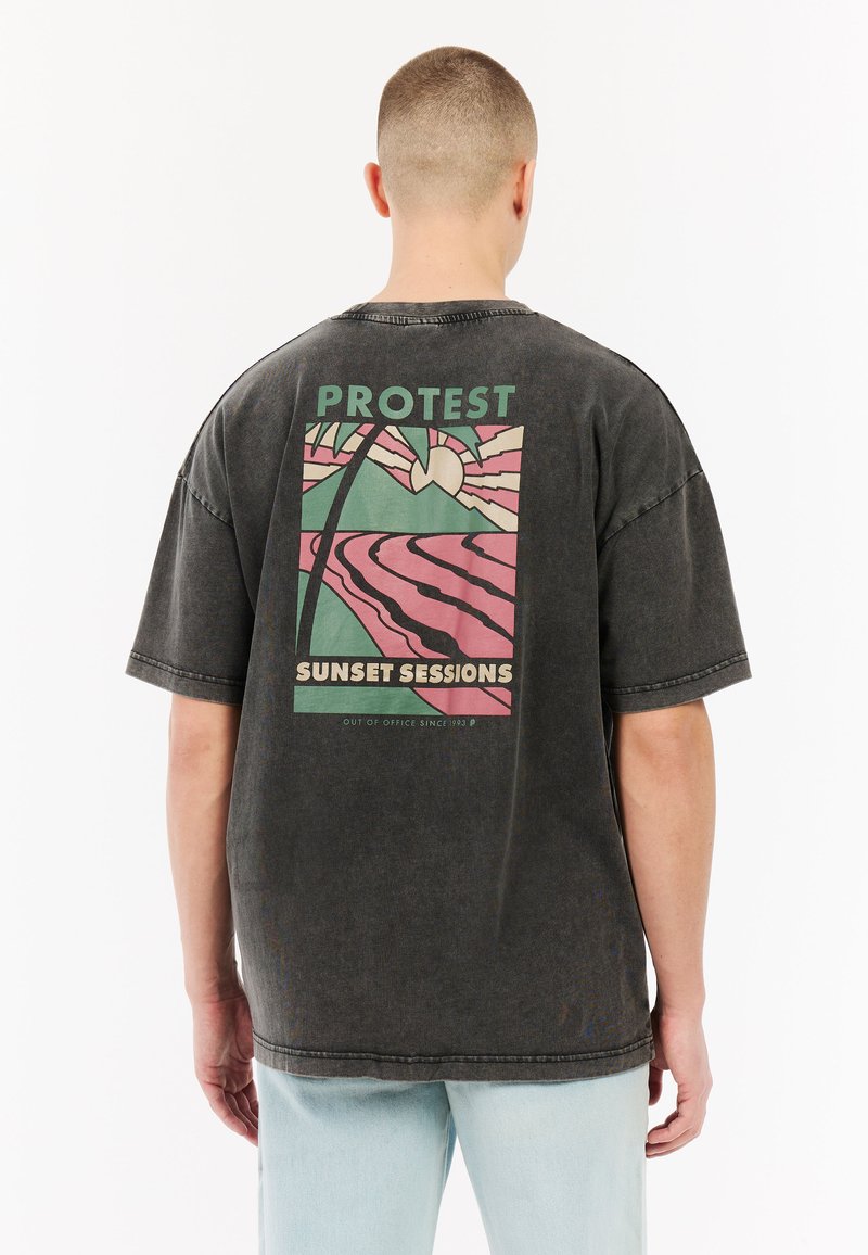 Over-sized zwart katoen t-shirt met een kleurrijke grafische print op de achterkant met palmbomen, zon en de tekst "PROTEST SUNSET SESSIONS."