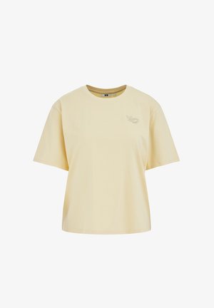 Krémsfarbené oversized tričko s krátkym rukávom, okrúhlym výstrihom a malým vyšívaným motívom listu a mušle na ľavej strane hrudníka.