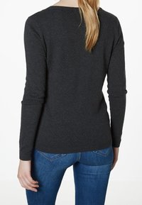 Pull gris foncé à manches longues avec un col rond. Confectionné en maille douce, il présente des poignets côtelés et un ourlet droit.