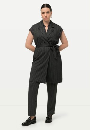 Ensemble de gilet croisé et de pantalon slim en gris foncé avec de fines rayures verticales. Le matériau semble texturé ; comprend une ceinture à nouer et des accents de boutons.