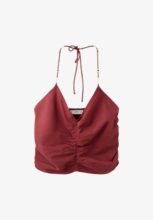 Červený crop top bez rukávov so riaseným predným dielom a tenkými nastaviteľnými halter ramienkami viazanými na krku na bielom pozadí.