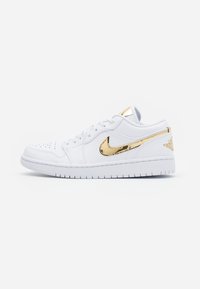 Baskets en cuir blanc avec un swoosh Nike doré brillant, des accents texturés et une semelle en caoutchouc blanc avec des détails perforés sur l'avant-pied.