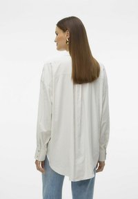 Camicia a maniche lunghe a righe in tessuto leggero, con righe verticali in crema e colori pastello, dal taglio rilassato e polsini con bottoni.