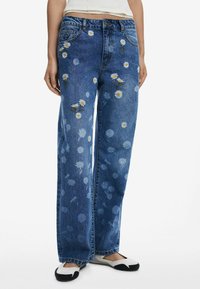 Blauwe denim wijde jeans met bloemenborduursels in geel en wit met madeliefjes, gestructureerde stof, vijf zakken en een knoopsluiting.