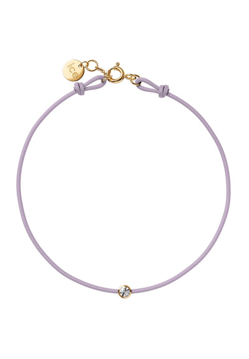 La pulsera de cordón lila presenta un pequeño cierre en tono dorado y un solo acento de cristal en el centro. Textura suave con un diseño minimalista.