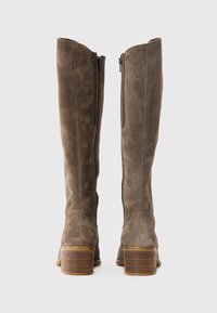 Knöchelhohe, braune Wildlederstiefel mit glatter Oberfläche, seitlichen Reißverschlüssen und einem gestapelten Holzabsatz, der ein elegantes und strukturiertes Design zeigt.