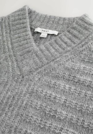 Gray knitted sweater with a v-neck design. Features a textured pattern and "NEXT" label on the collar. Soft and cozy material.