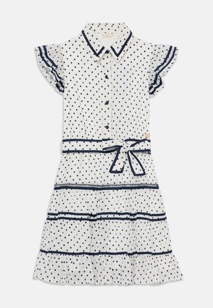 Abito bianco con pois blu navy. Maniche corte a volant, chiusura con bottoni frontale e vita annodata. Presenta volant sovrapposti all'orlo e una rifinitura a contrasto.