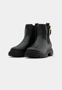 Black leather ankle boots with a chunky sole, side buckle detail, and smooth texture. Features pull tab for easy wear.