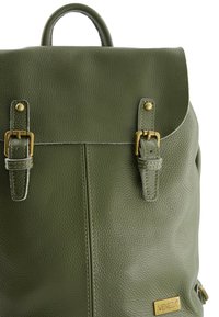 Groene leren rugzak met een textured afwerking. Heeft twee gespsluitingen, een bovenhandvat en een gouden merkplaat.
