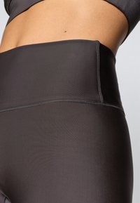 Kõrgelturi mustad legginsid, mis on valmistatud siledast ja venivast kangast. Omavad lamedaid õmblusi ja probleemivaba vööosa mugavuse ja paindlikkuse tagamiseks.