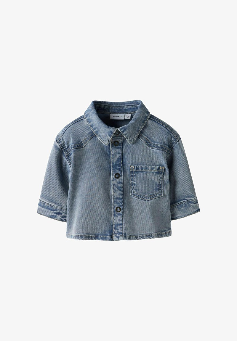 Veste en jean bleu clair à manches courtes avec col, poche frontale sur le côté gauche et boutons noirs sur le devant.