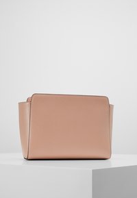 Růžová kožená taška v jemném odstínu, se strukturovaným obdélníkovým tvarem, mírně texturovaným povrchem a minimalistickým designem. Žádné viditelné kovové prvky nebo akcenty.