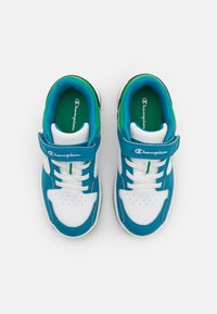 Blau-weiße Sportschuhe mit glattem Lederoberfläche, ausgestattet mit Schnürung und Klettverschluss, sowie grünen Akzenten auf den Innensohlen.